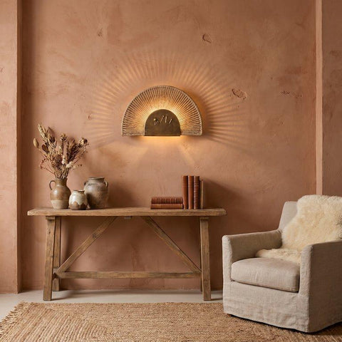 Sun-inspired bronze wall lamp with ropes